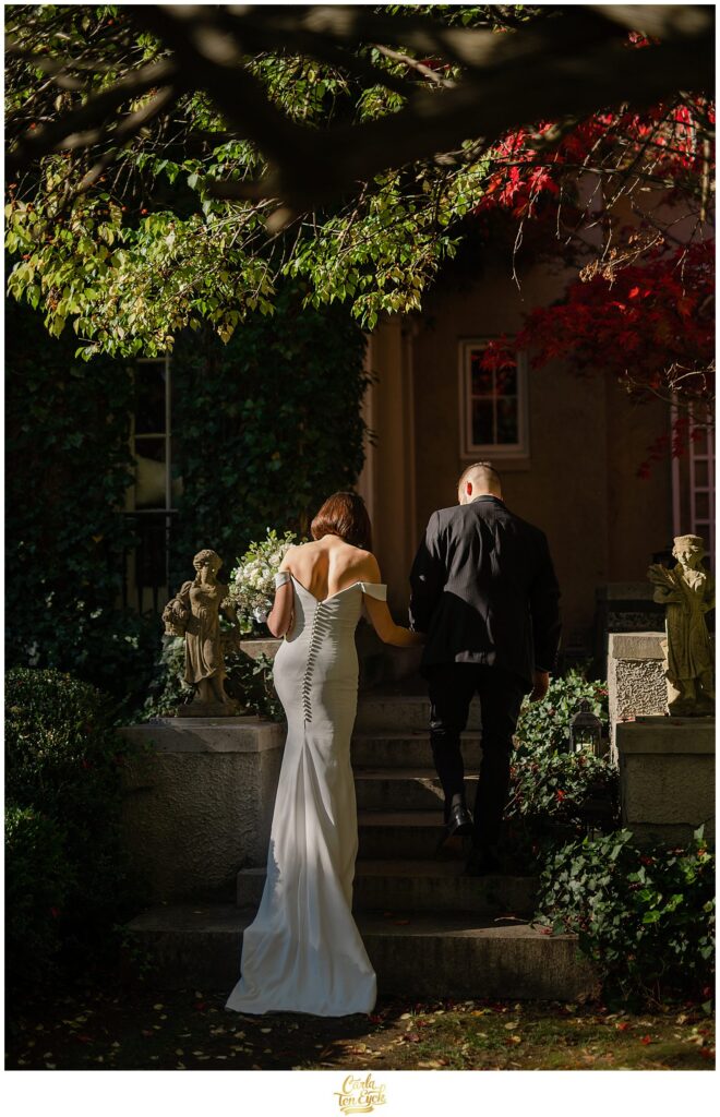 A bride and groom walk up the stairs for their wedding photos at Lord Thompson Manor in Thompson CT