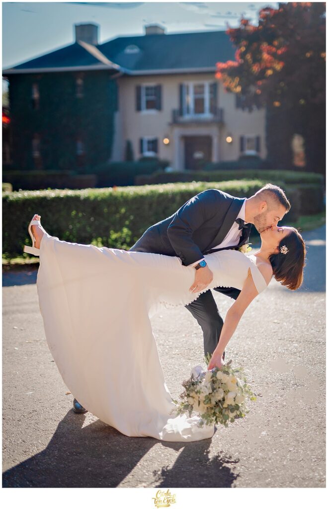 A groom dips his bride at their wedding at Lord Thompson Manor in Thompson CT
