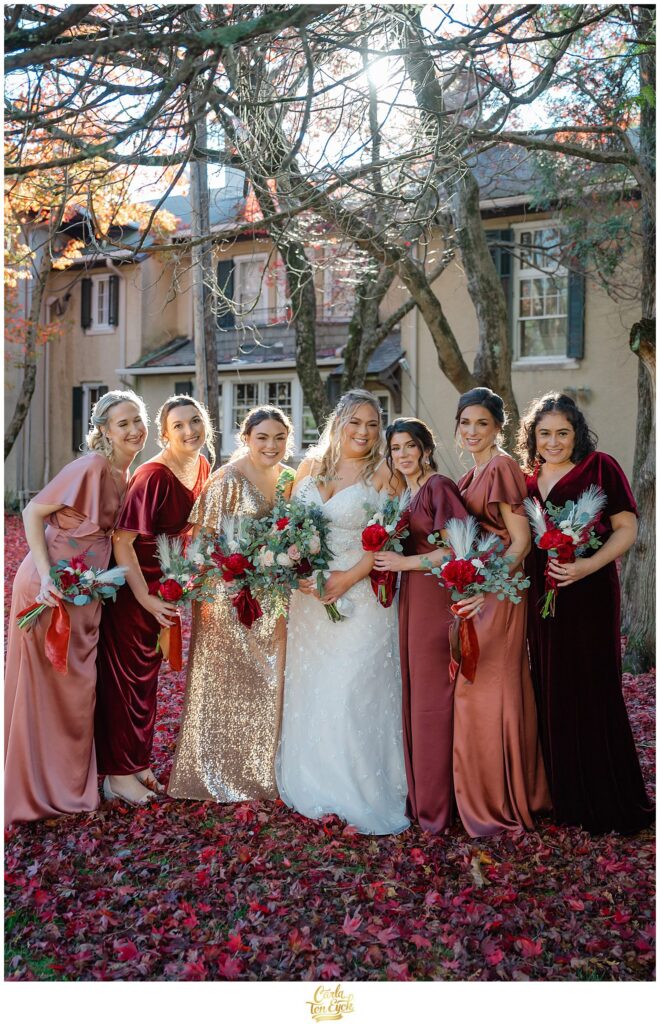 A bride and her wedding party smile for photos at an  autumn lord Thompson Manor wedding in Thompson CT