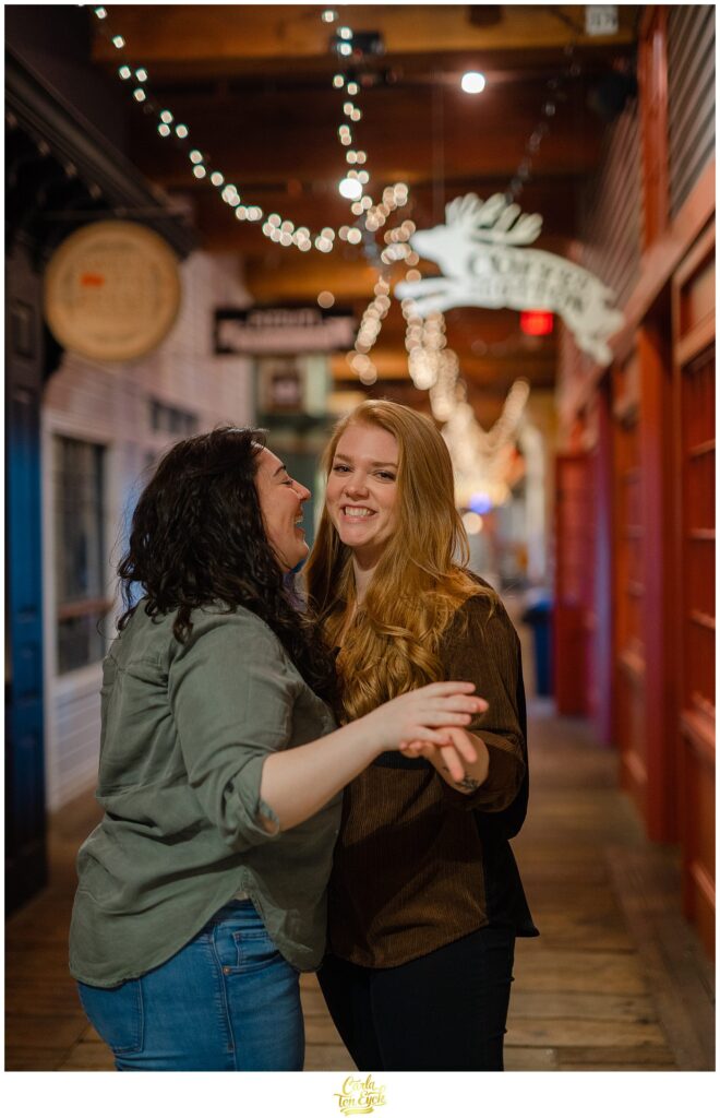 Two brides laugh in the hallways during their engagement session at  Mill NO. 5 in Lowell MA