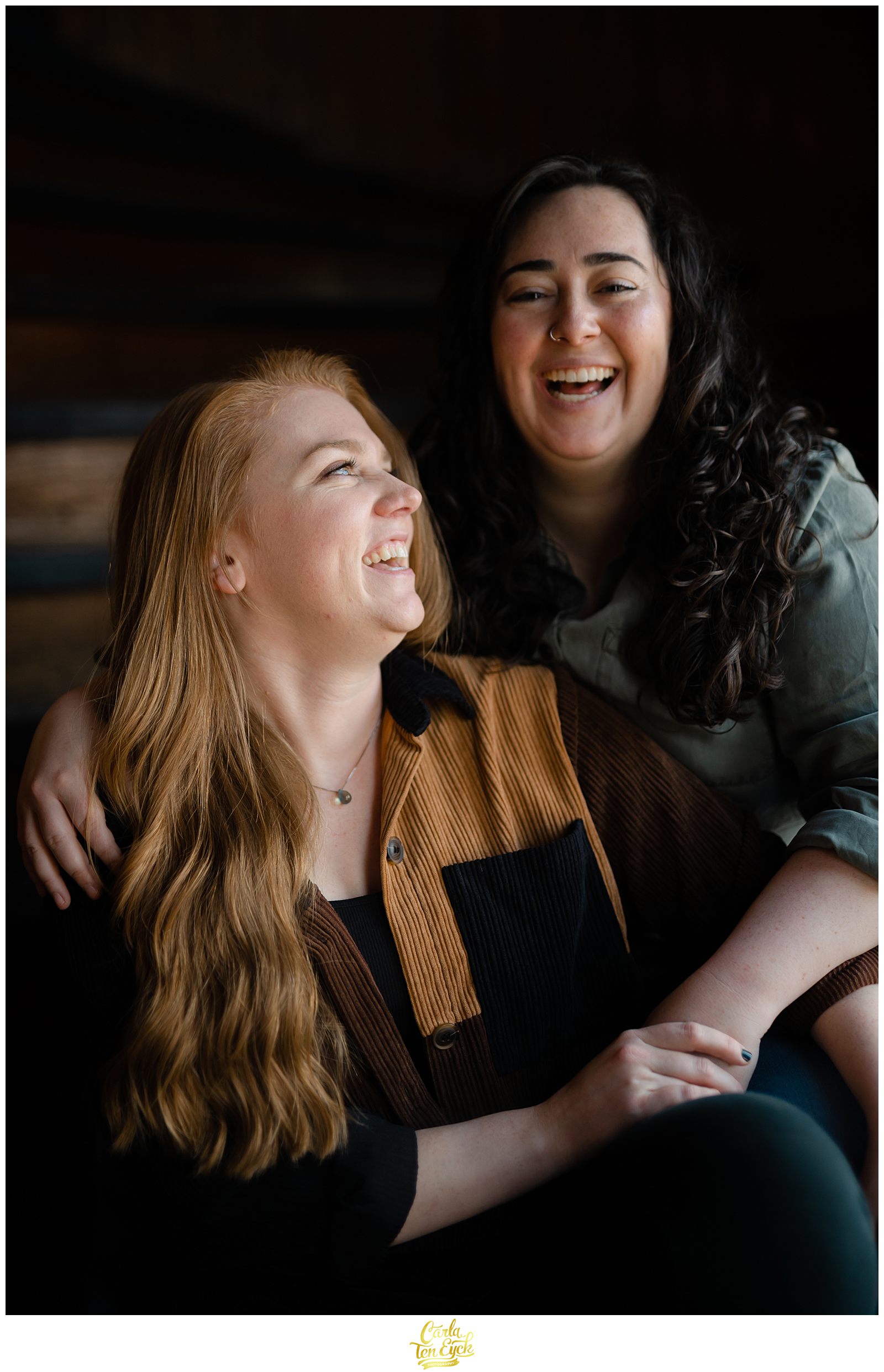 Two brides laugh during their engagement session at Mill NO. 5 in Lowell MA