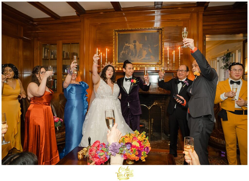 A couple toasts at their colorful wedding at Lord Thompson Manor wedding in Thompson CT