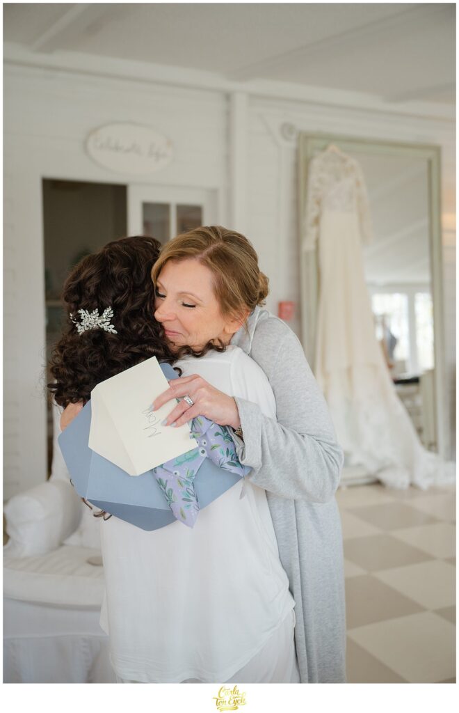 A mom embraces her daughter at her romantic wedding at Lord Thompson Manor in Thompson CT
