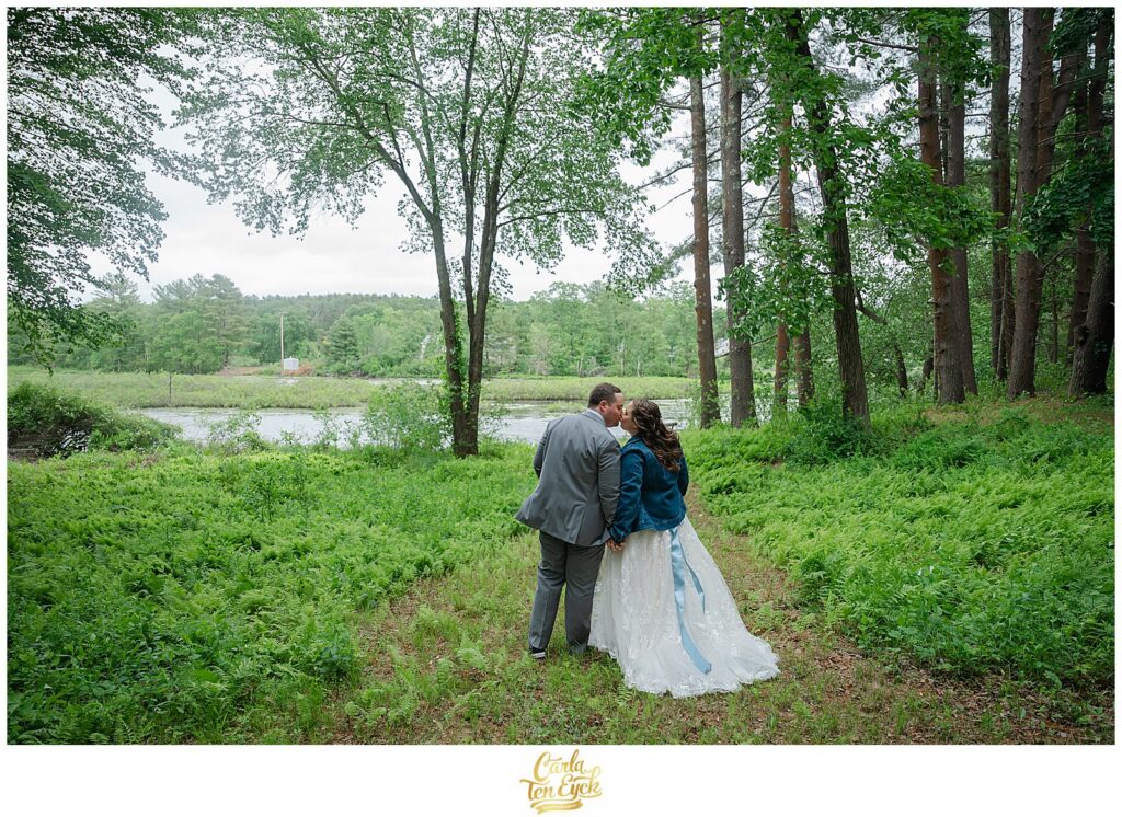 A bride and groom kiss in the ferns at their Pinecroft Estate Wedding in Thompson CT
