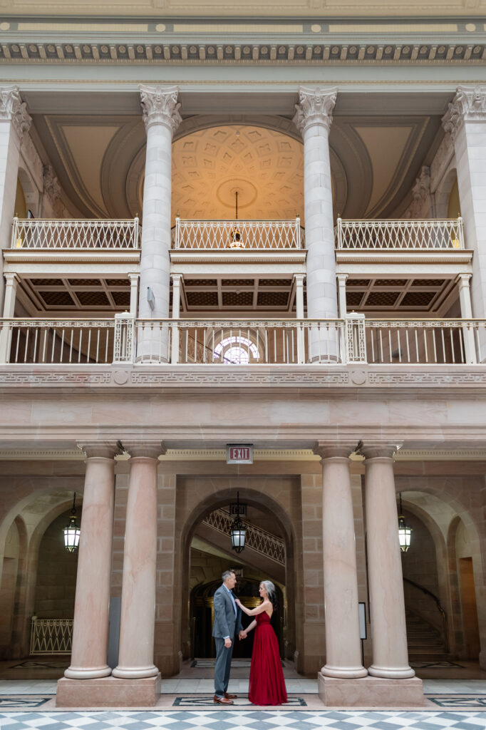 A couple takes a breath before their Hartford City Hall elopement in a colorful red dress