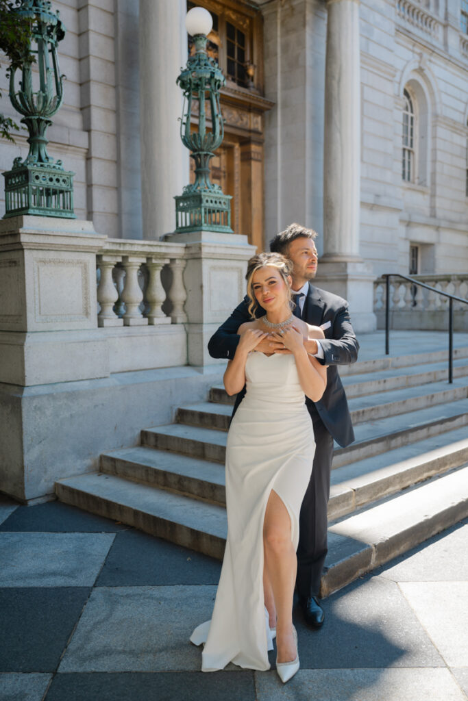 A bride and groom snuggle on the front steps of the iconic Hartford City Hall after their elopement in Hartford CT.