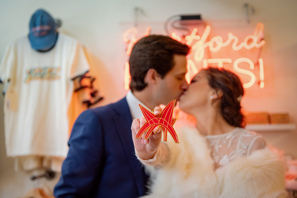 A couple poses with an ornament of Calder's Stegosaurus sculpture in Hartford Prints! after their Hartford City Hall elopement.