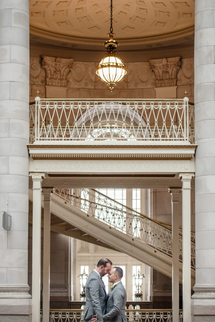 Two grooms snuggle up after their Hartford City Hall elopement in Hartford CT.