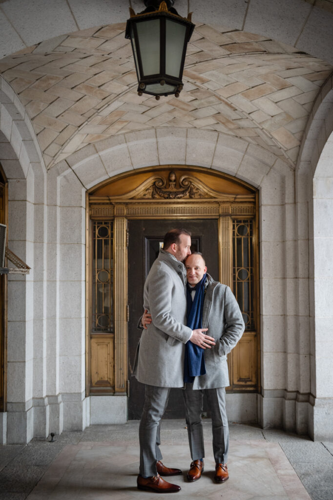 Two grooms snuggle to keep warm outside Hartford City Hall after their elopement in Hartford CT.