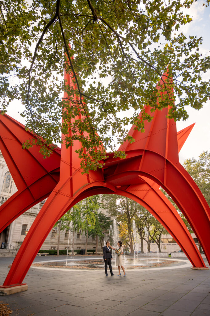 Two brides elope at Hartford City Hall then pose for photos under the Calder sculpture Stegosaurus in Hartford CT