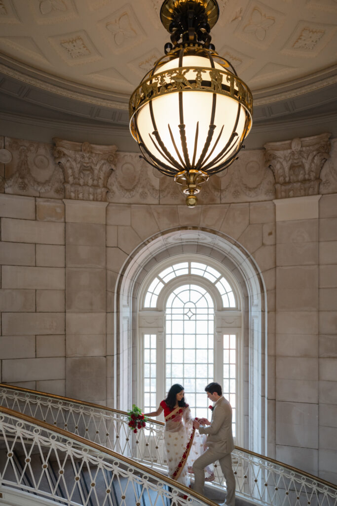 A couple poses on the iconic staircase before their Hartford City Hall elopement