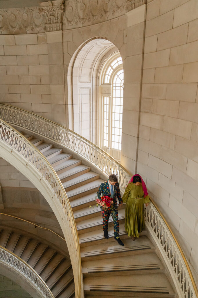 Two brides on the iconic staircase at their colorful Hartford City Hall elopement in Hartford CT