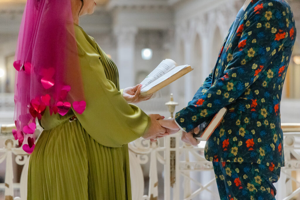 Two brides hold their vow books at their colorful Hartford City Hall Elopement in Hartford CT