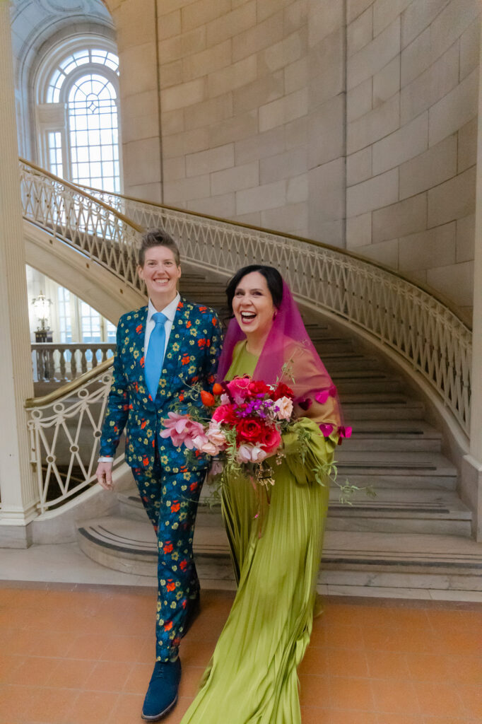Two brides on the epic staircase of Hartford City Hall at their colorful elopement in Hartford CT