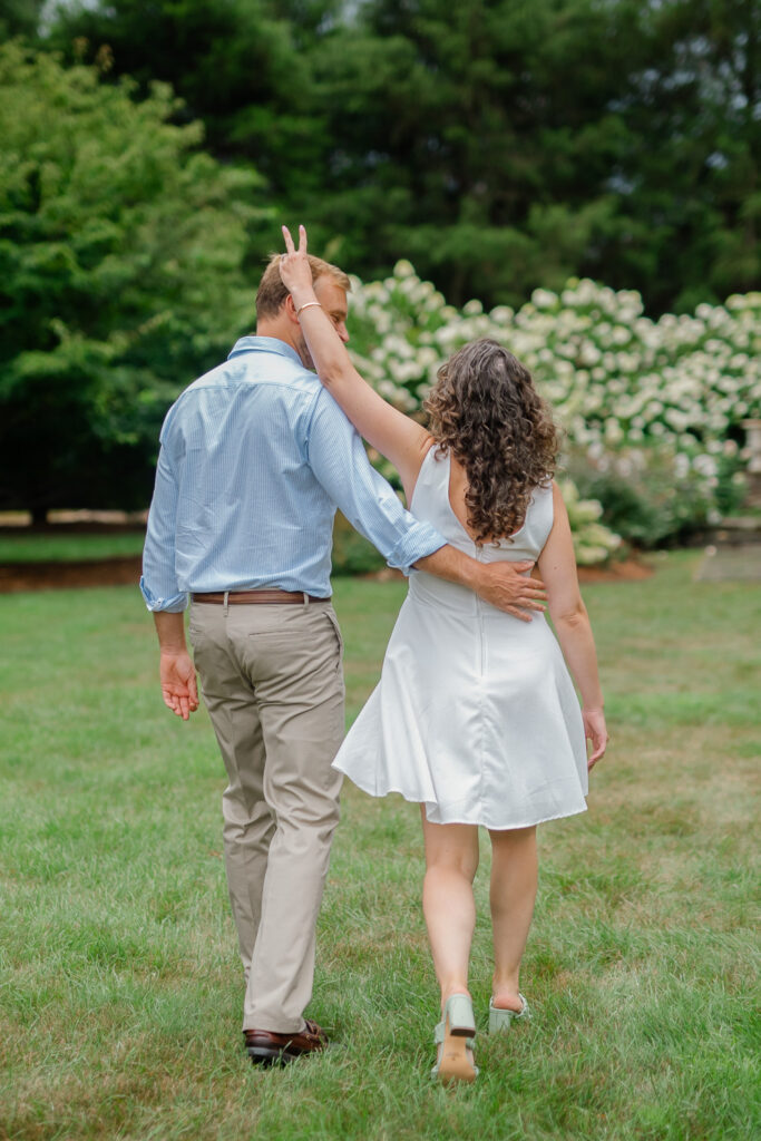 A camera shy couple walks during their engagement session at The Wadsworth Mansion in Middletown CT with Connecticut photographer Carla Ten Eyck