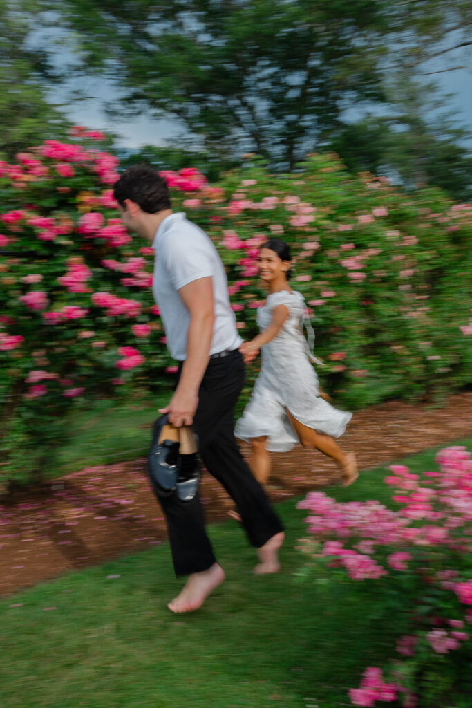 A camera shy couple runs in the rose garden at Elizabeth Park Hartford CT photographed by Carla Ten Eyck