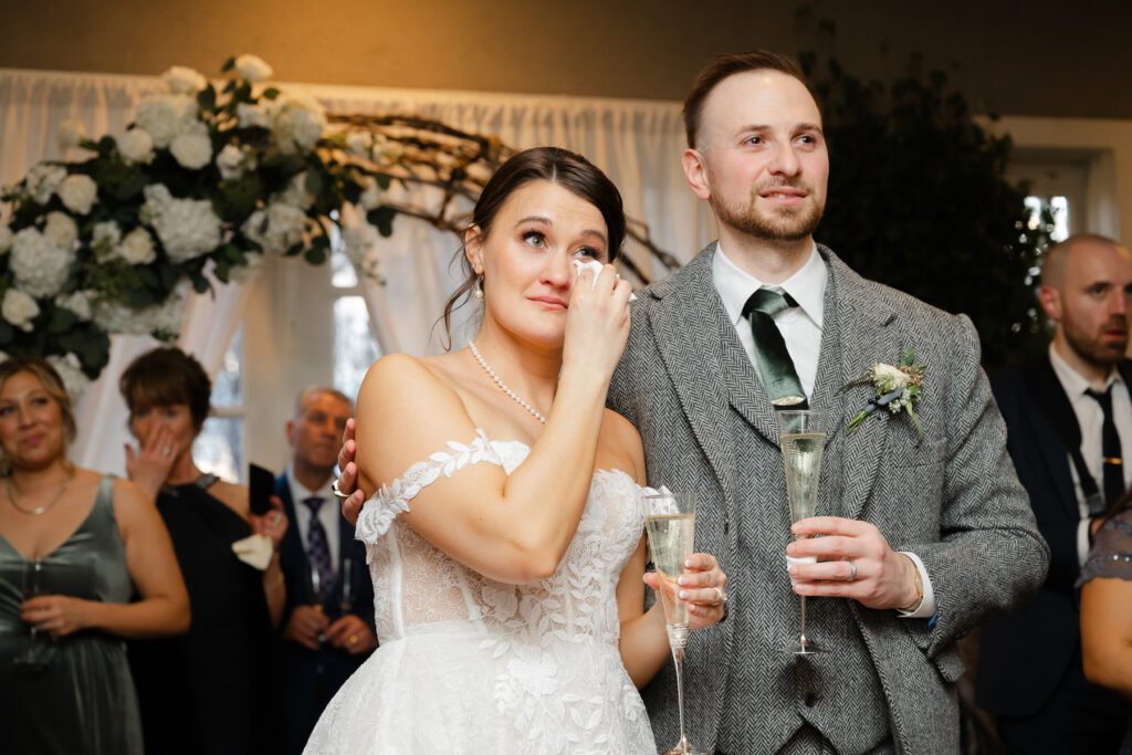 A bride cries during her wedding toasts in the ballroom during her Lord Thompson Manor wedding in Thompson CT