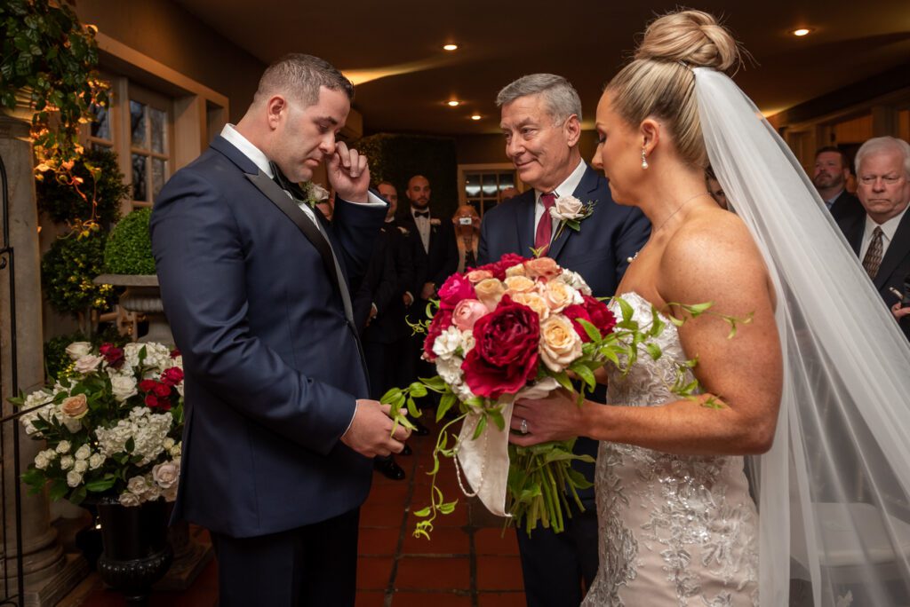 A groom gets emotional during his rainy wedding ceremony at Lord Thompson Manor in Thompson CT