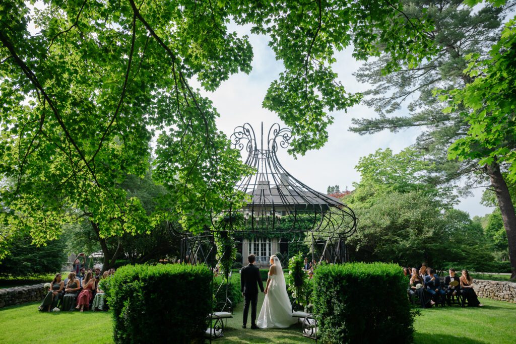 A bride and groom during their outdoor wedding ceremony at Lord Thompson Manor in Thompson CT