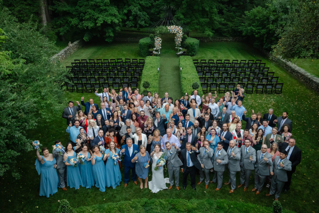 Wedding guests toast during their group photo after the toasts at Lord Thompson Manor in Thompson CT