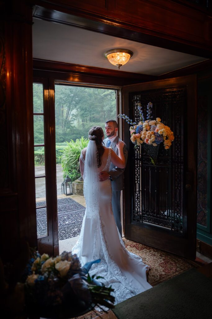 A bride and groom have a quiet moment during their rainy portrait session at their Lord Thompson Manor wedding in Thompson CT